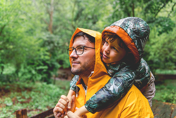 father and son hiking in the rain