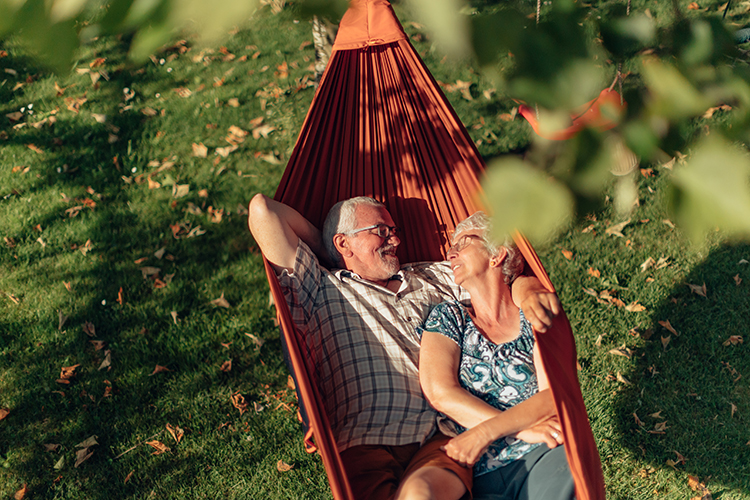 retired couple relaxing in hammock